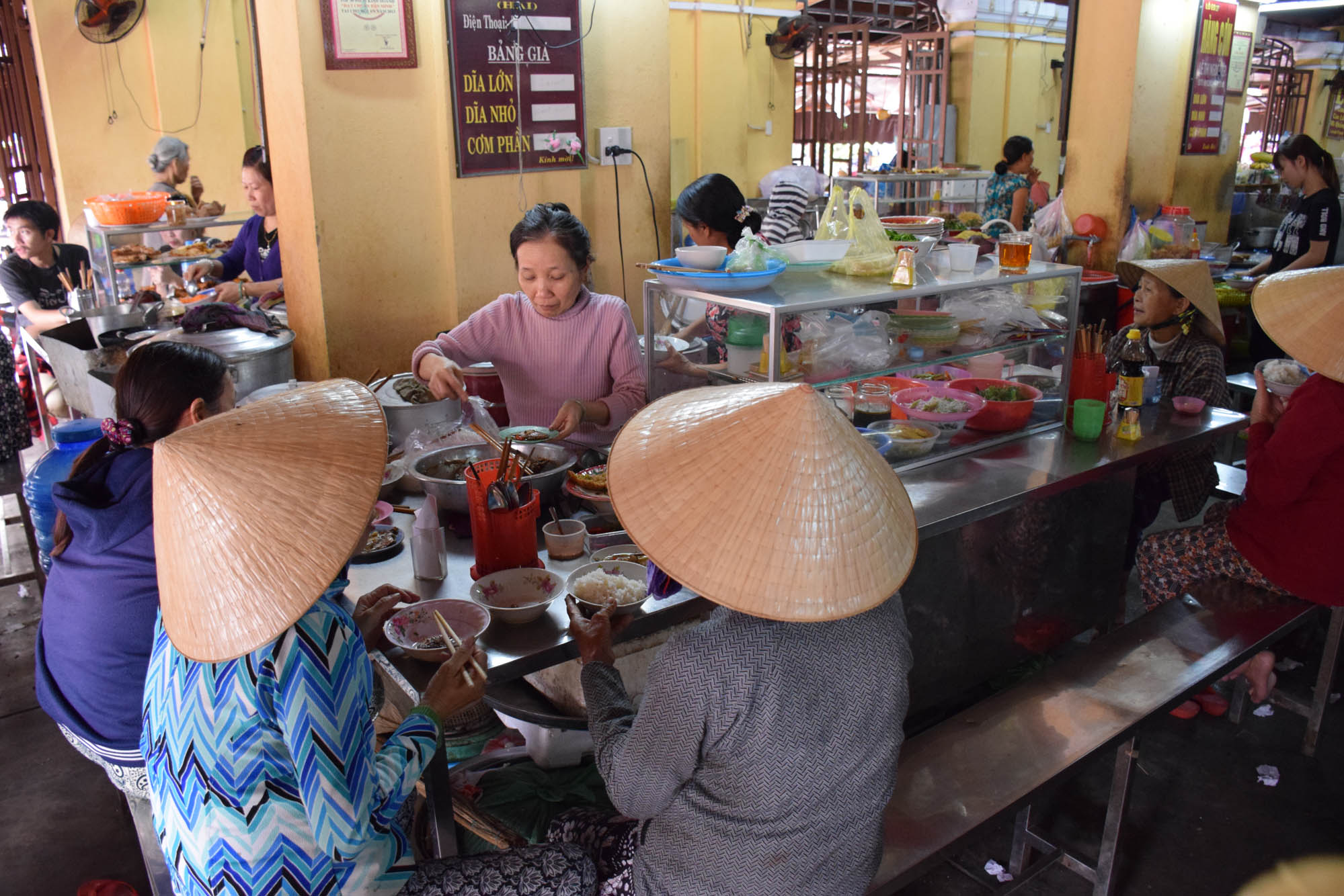 Vietnamitas almoçando no Mercado Central de Hoi An (muito fofas de chapeuzinho, né?!)