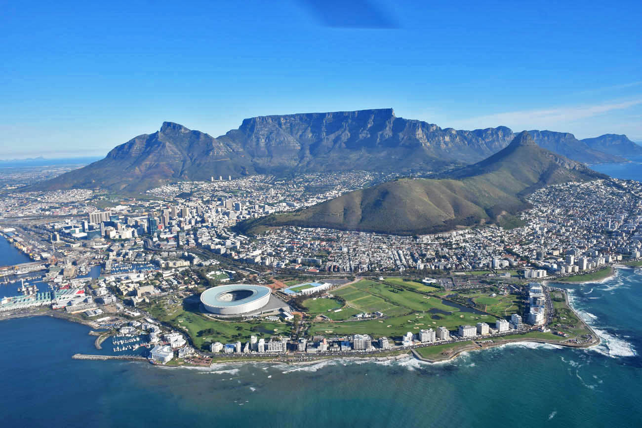Table Mountain atrás e o estádio na frente | Sobrevoando a Cidade do Cabo de helicóptero - NAC Helicopters 